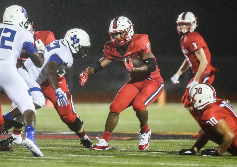 Melissa running back Ja'Bray Young (5) works to break past the Trinity Christian defensive...
