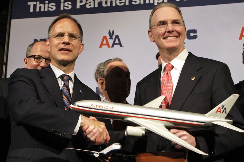 ORG XMIT: NYFF105 American Airlines CEO Gerard Arpey, right, shakes hands with JetBlue CEO...