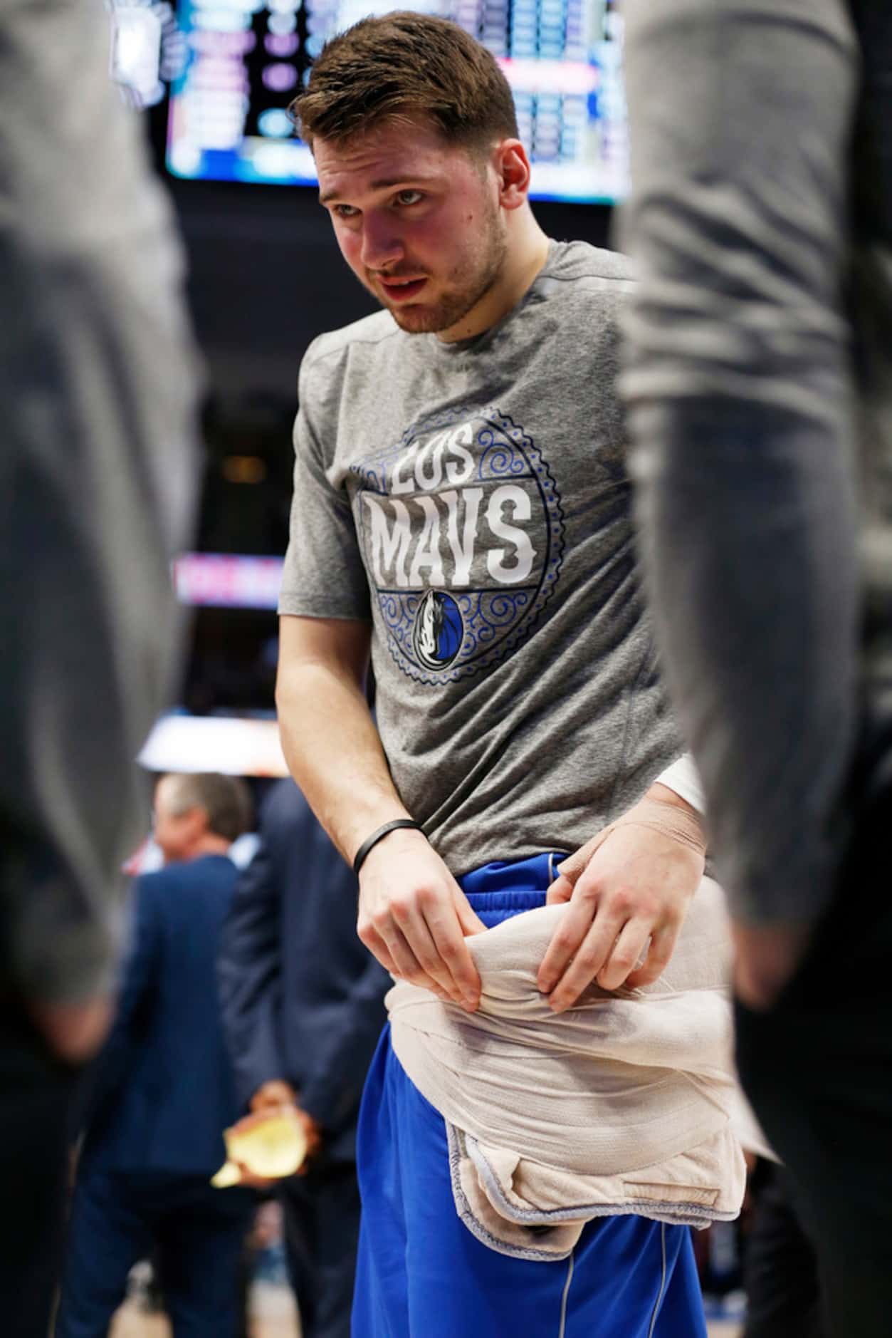 Dallas Mavericks guard Luka Doncic (77) adjusts a wrap on his waist before going back out to...