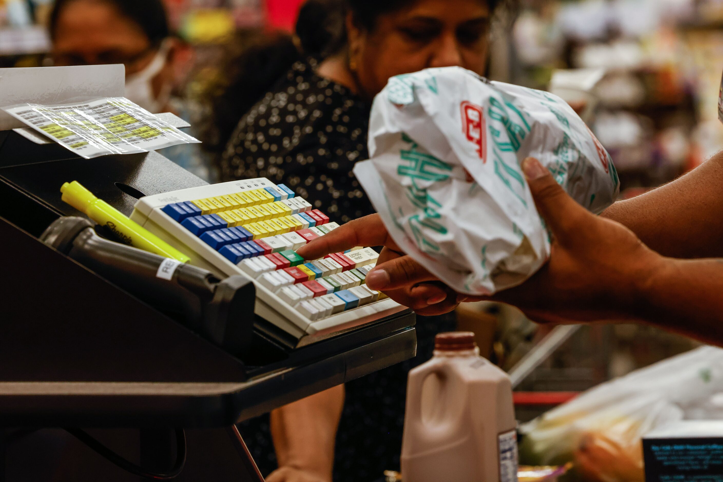 An H-E-B A cashier records a customer's purchase at the new store that opened its doors to...