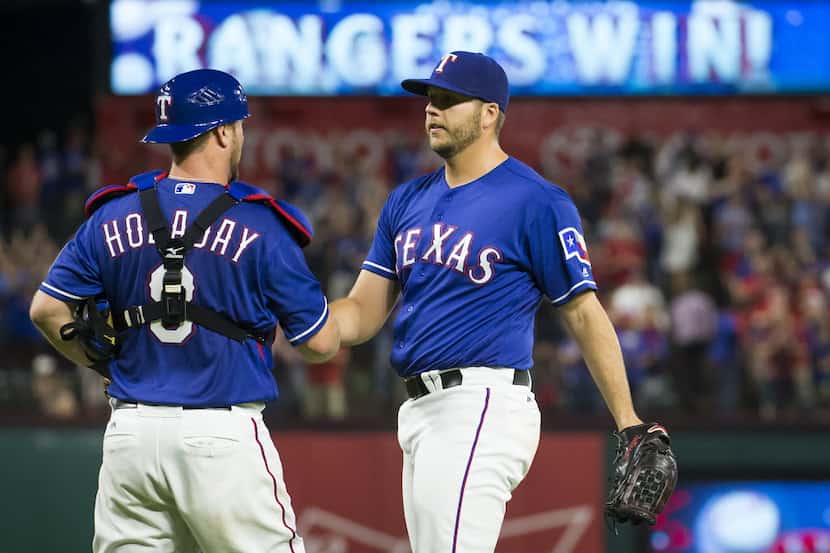 Texas Rangers relief pitcher Shawn Tolleson shakes hands with catcher Bryan Holaday after...