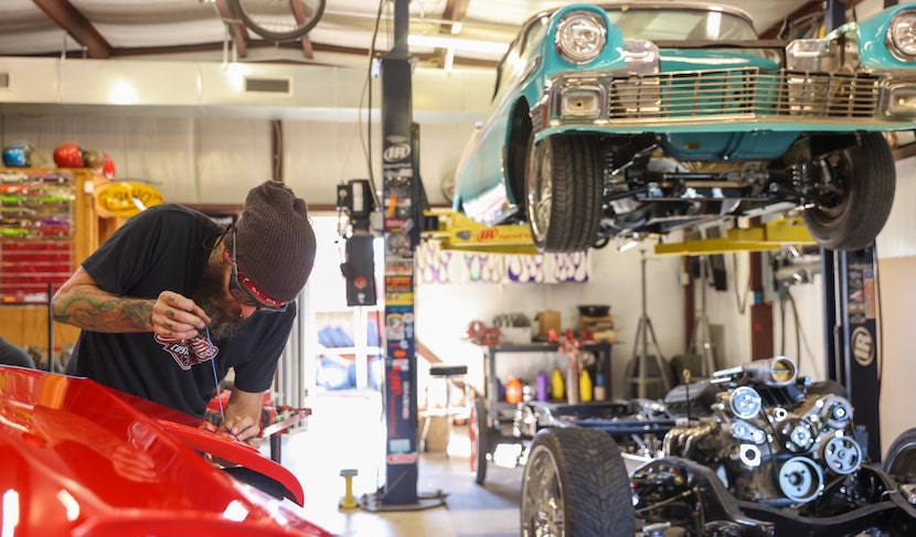 Body and fabrication specialist Charlie Chaffin tapes the edges of an exterior piece of a...