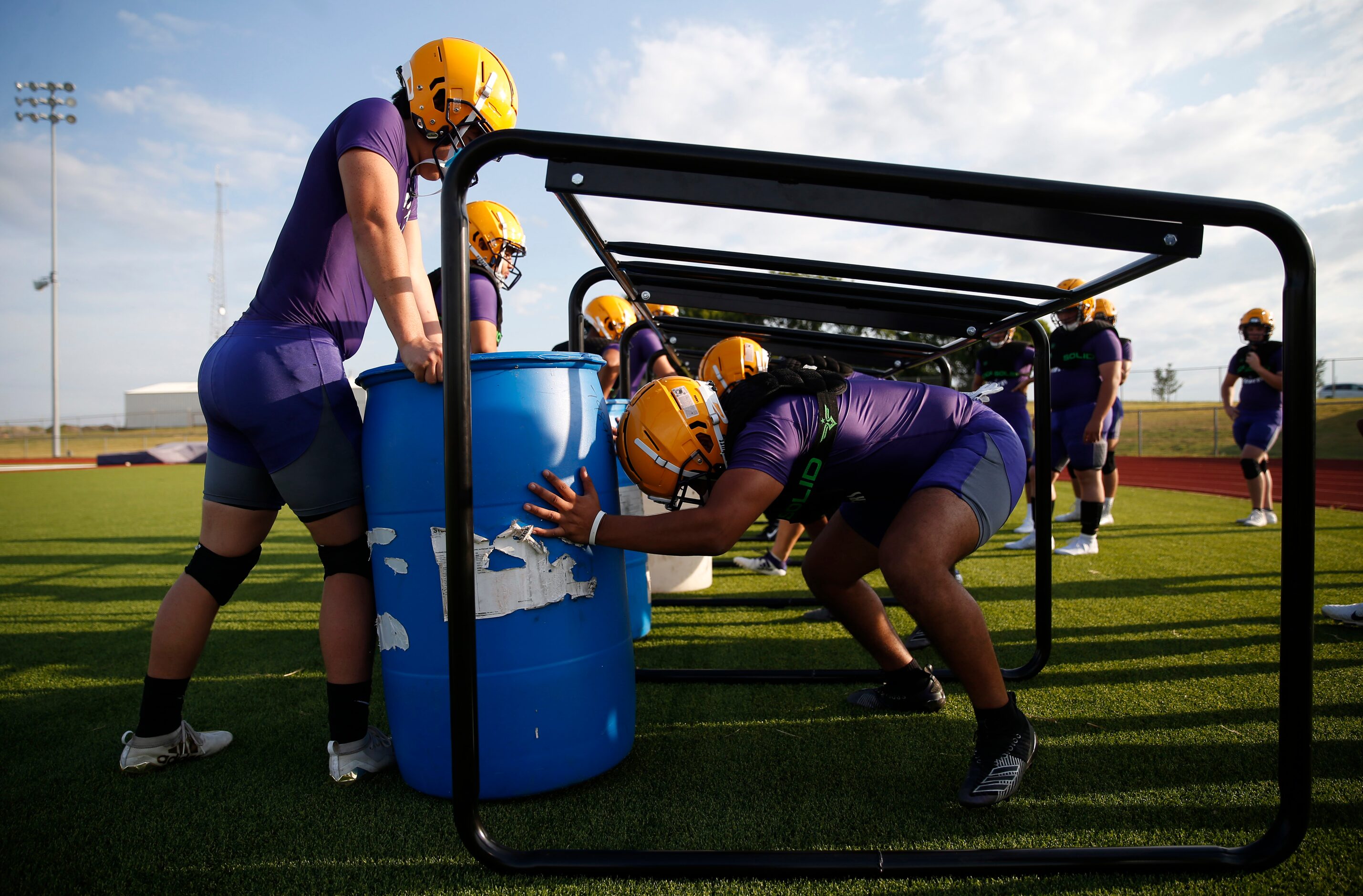 Farmersville's Eber Padilla (right) pushes on a barrel held by Farmersville's Jordan Herring...