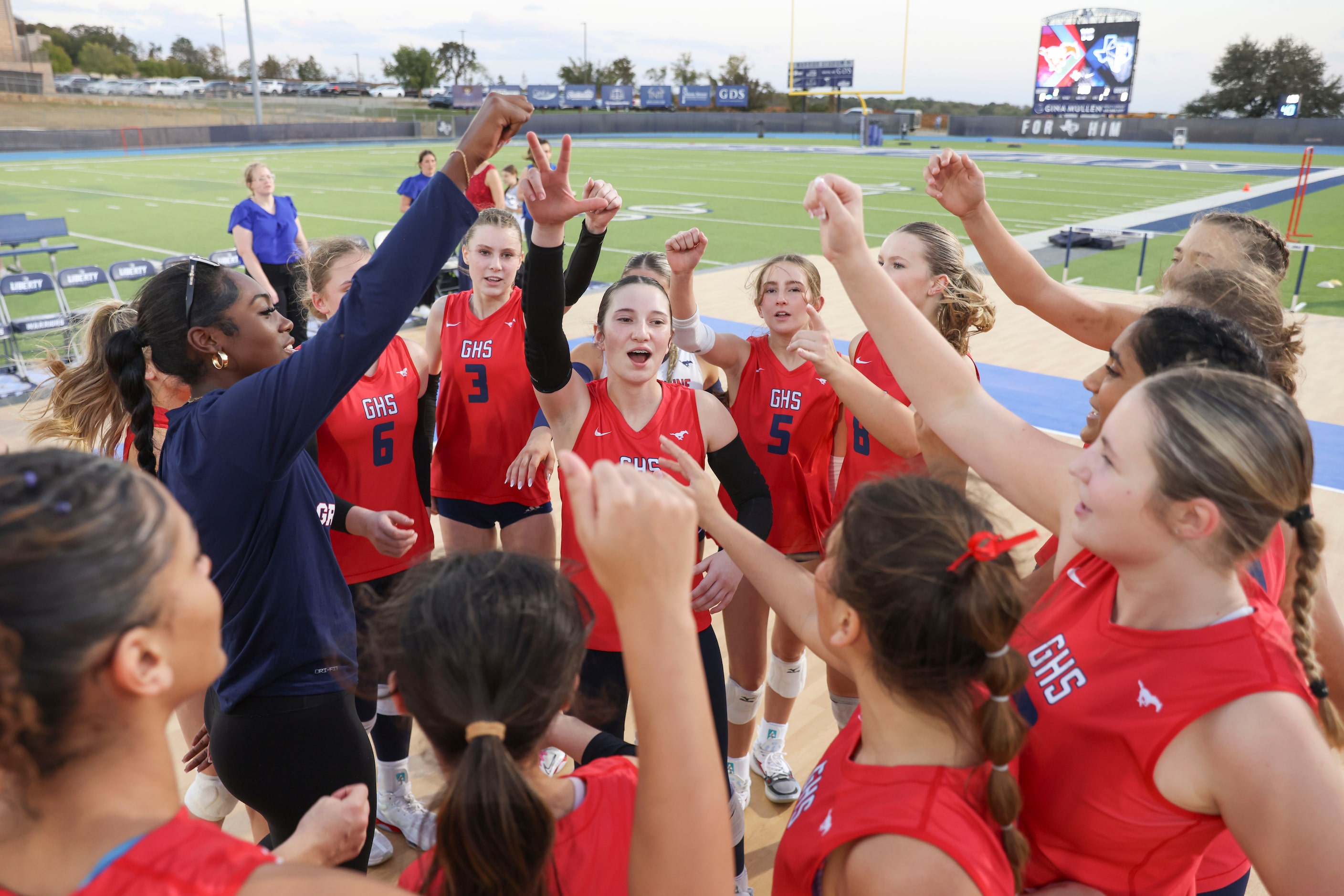 Grapevine High School players cheer following a team huddle ahead of an outdoor volleyball...