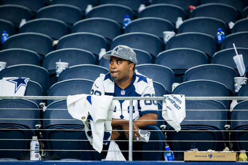A Dallas Cowboys fan sits in his seat disappointed after a 34-31 to the Green Bay Packers at...