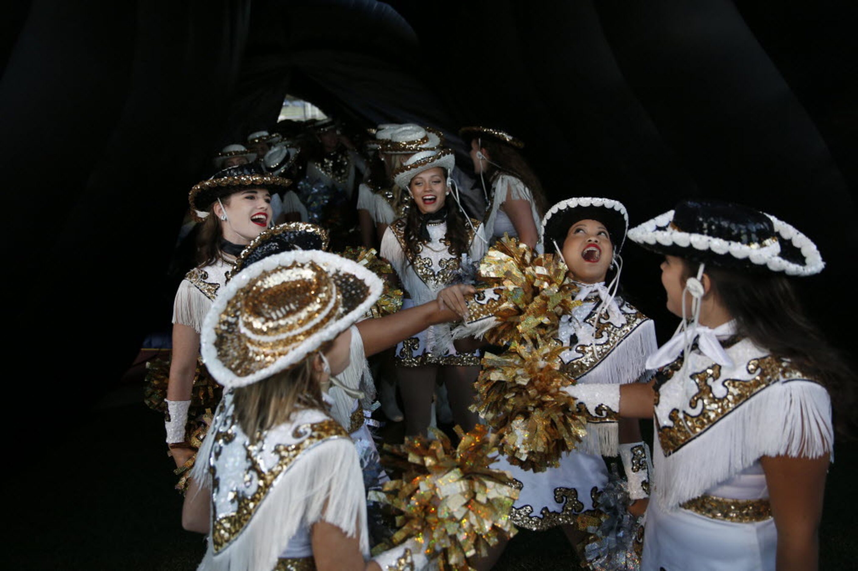 Plano East Golden Girls drill team members prepare to walk onto the field before a high...