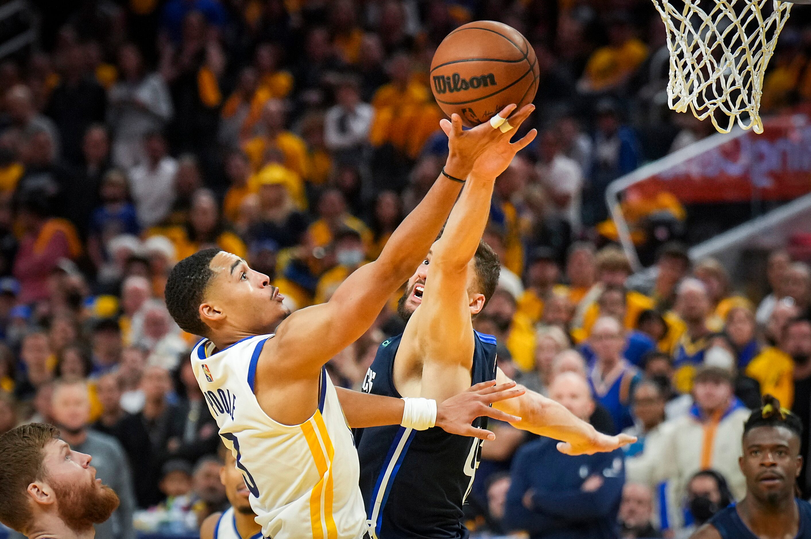 Golden State Warriors guard Jordan Poole (3) scores past Dallas Mavericks forward Maxi...