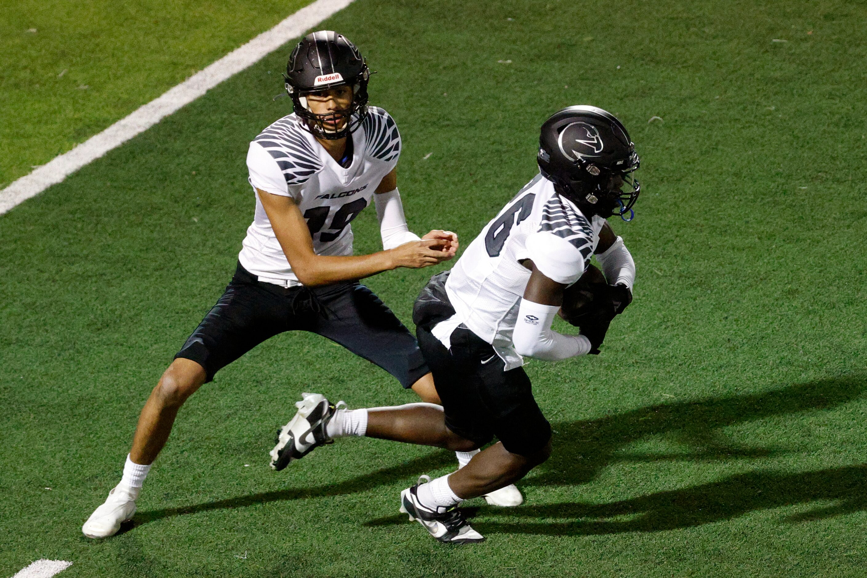 North Forney quarterback Edward Reyes 919) hands the ball to running back Andikan Asuquo...