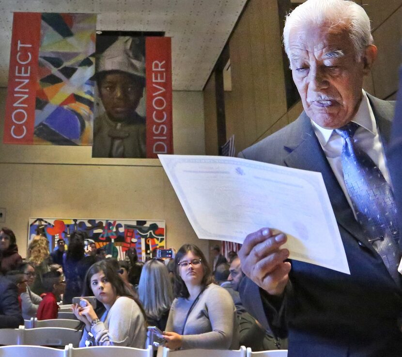 85-year-old Carlos Chavez from Mexico checks out his citizenship certificate after being...