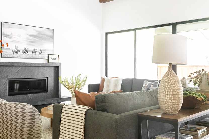 Living room with couch and chairs in front of a fireplace, with TV hanging above the mantel