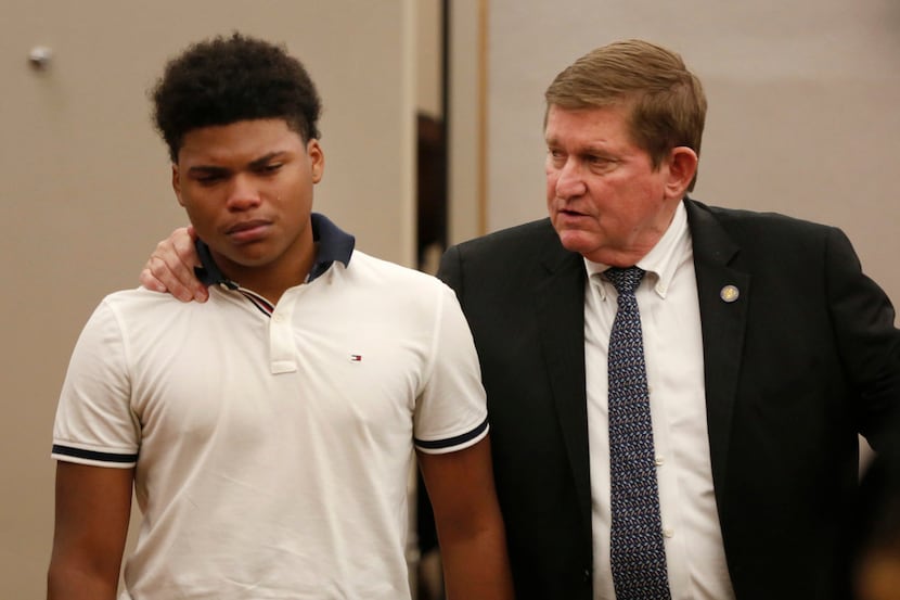 Prosecutor Michael Snipes comforts 17-year-old Maxwell Everette after tearful testimony...
