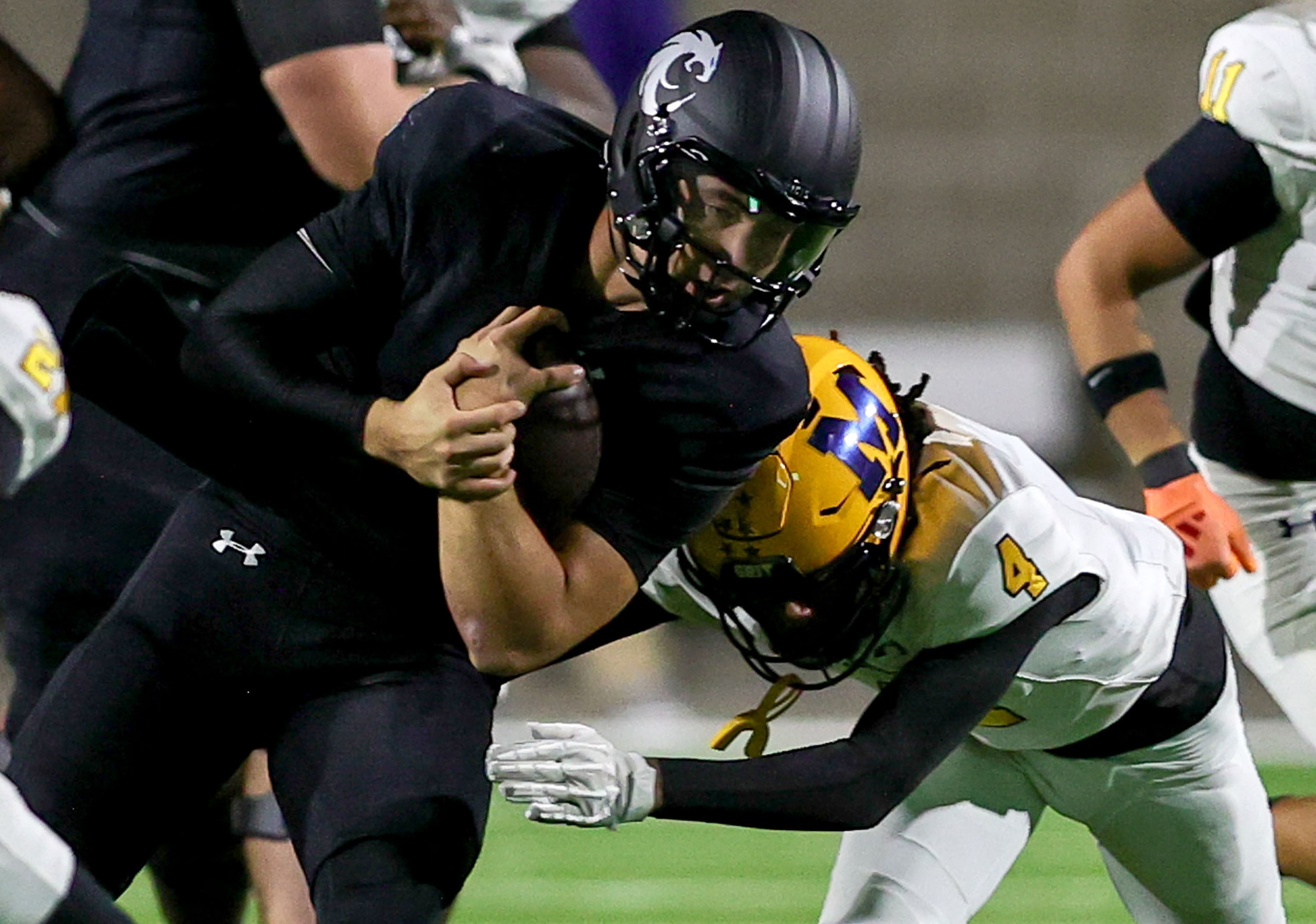 Denton Guyer quarterback Kevin Sperry (L) is hit hard by McKinney defensive back Ja'bree...