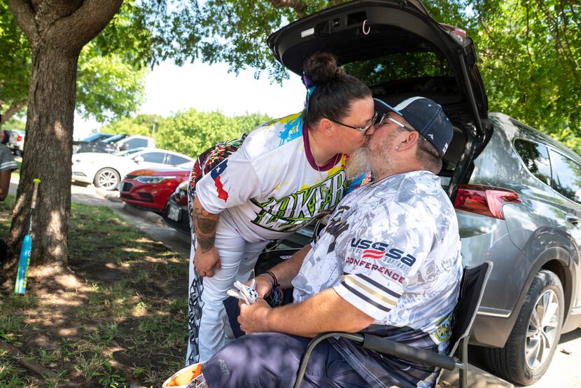 Natasha Reeves gives her husband, Jim Reeves, a kiss before joining a softball game at Kiest...