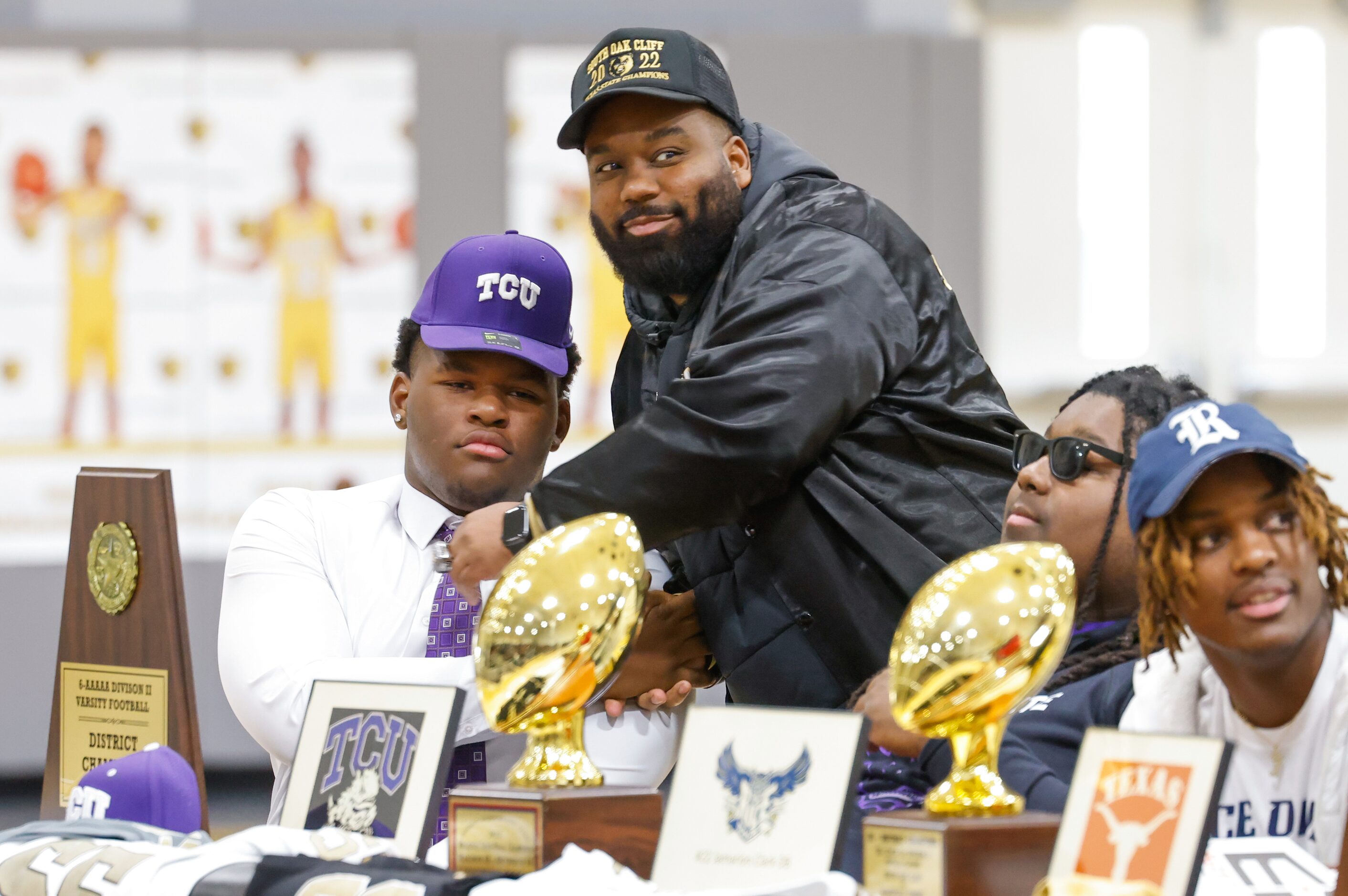 South Oak Cliff football player Narado Stoker (left) is pulled into a handshake from coach...