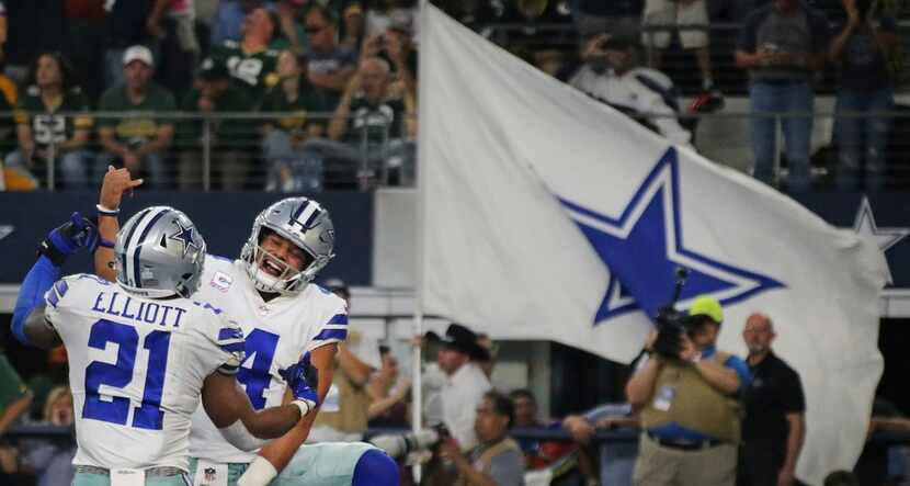 Dallas Cowboys quarterback Dak Prescott (4) celebrates with running back Ezekiel Elliott...