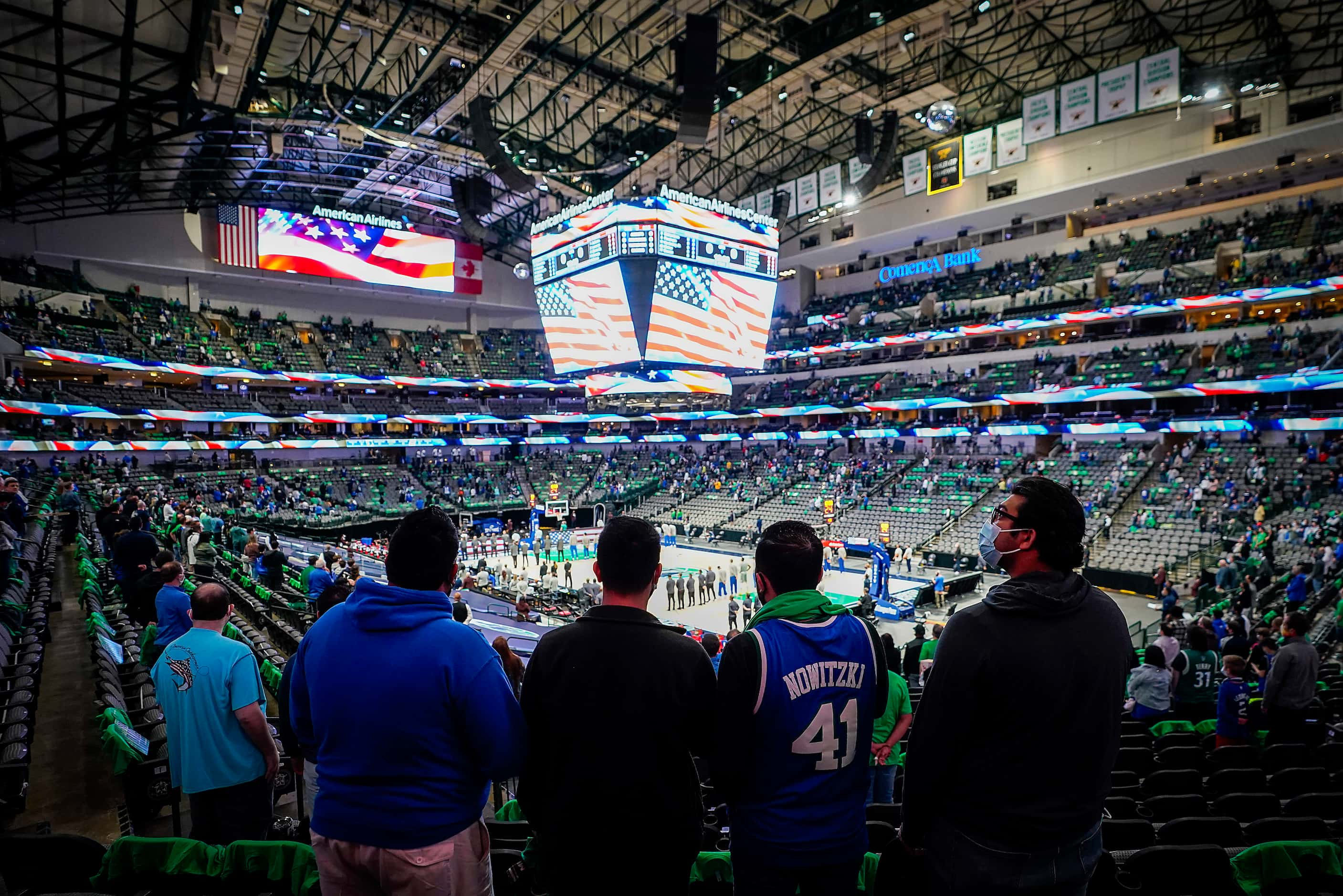 Dallas Mavericks fans stand for the national anthem before an NBA basketball game against...