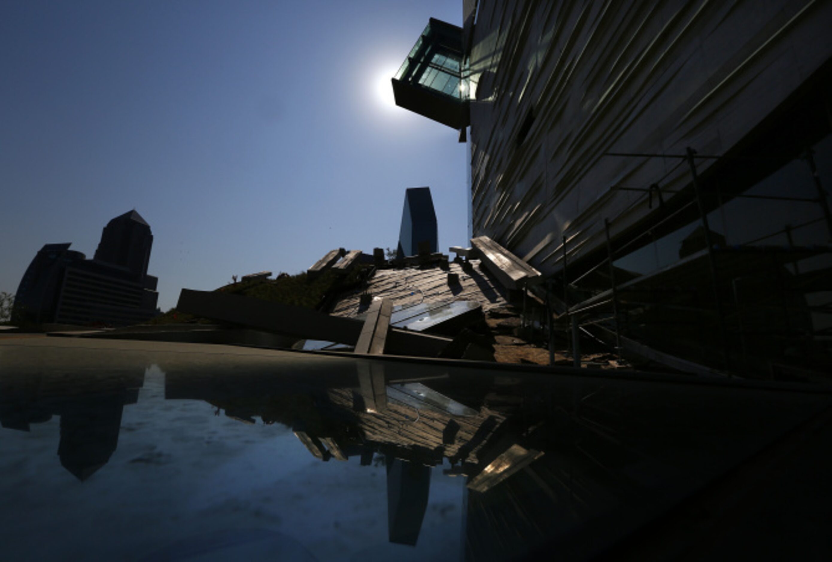 Part of the glass-enclosed continuous-flow escalator projects from the edge of the Perot...