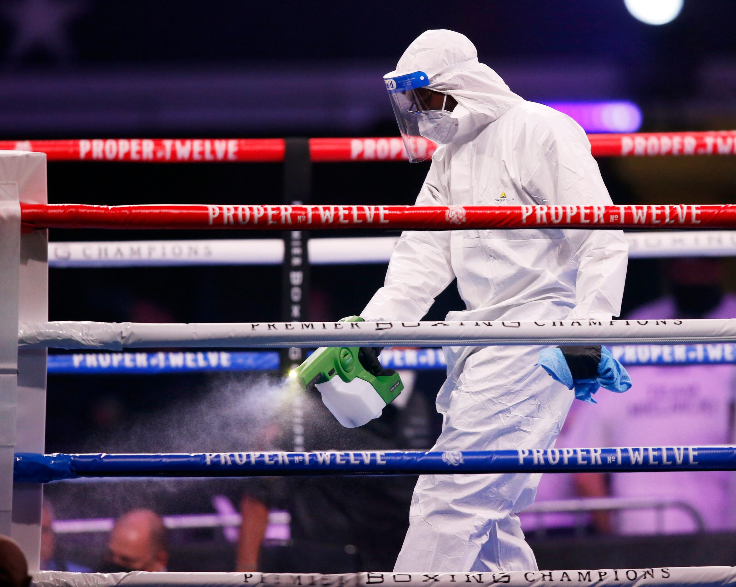 A cleaning crew in protective gear cleans the rings after a fight between Burley Brooks and...