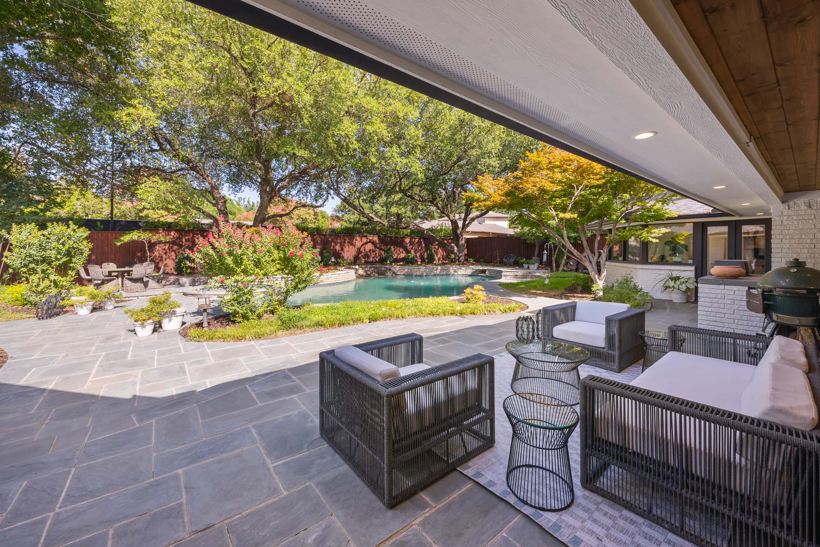 View of backyard from back patio, patio spaces, pool nearby, landscaped yard