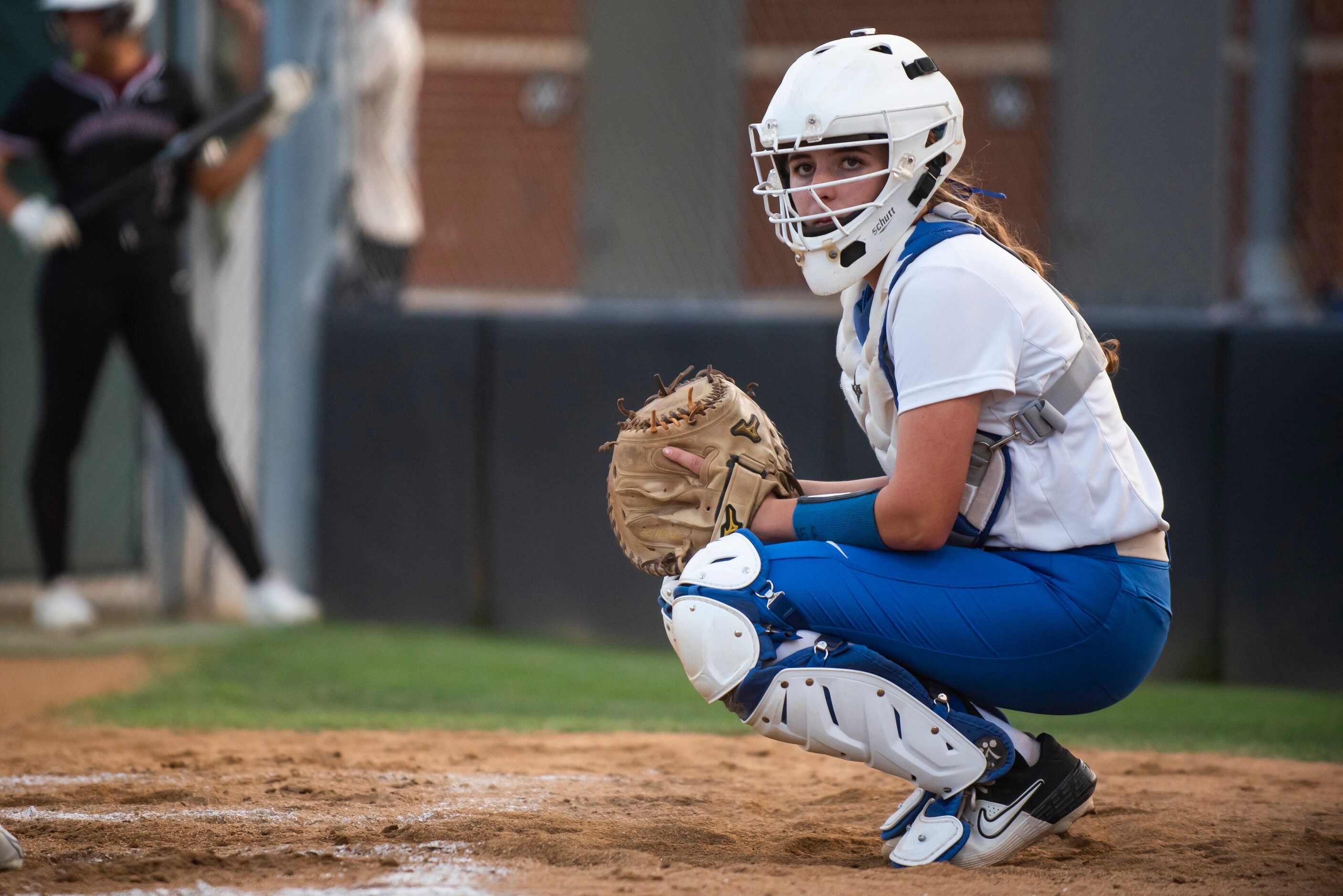 Hebron catcher Zoe Bowen (15) looks over at the dugout for a pitching call from her manager...