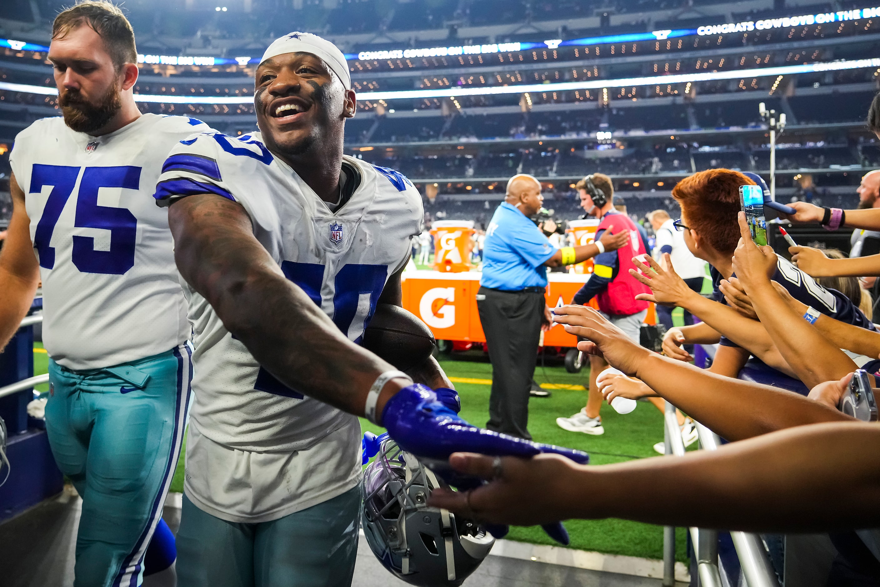 Dallas Cowboys safety Juanyeh Thomas (40) carries a game ball as he leaves the field after a...