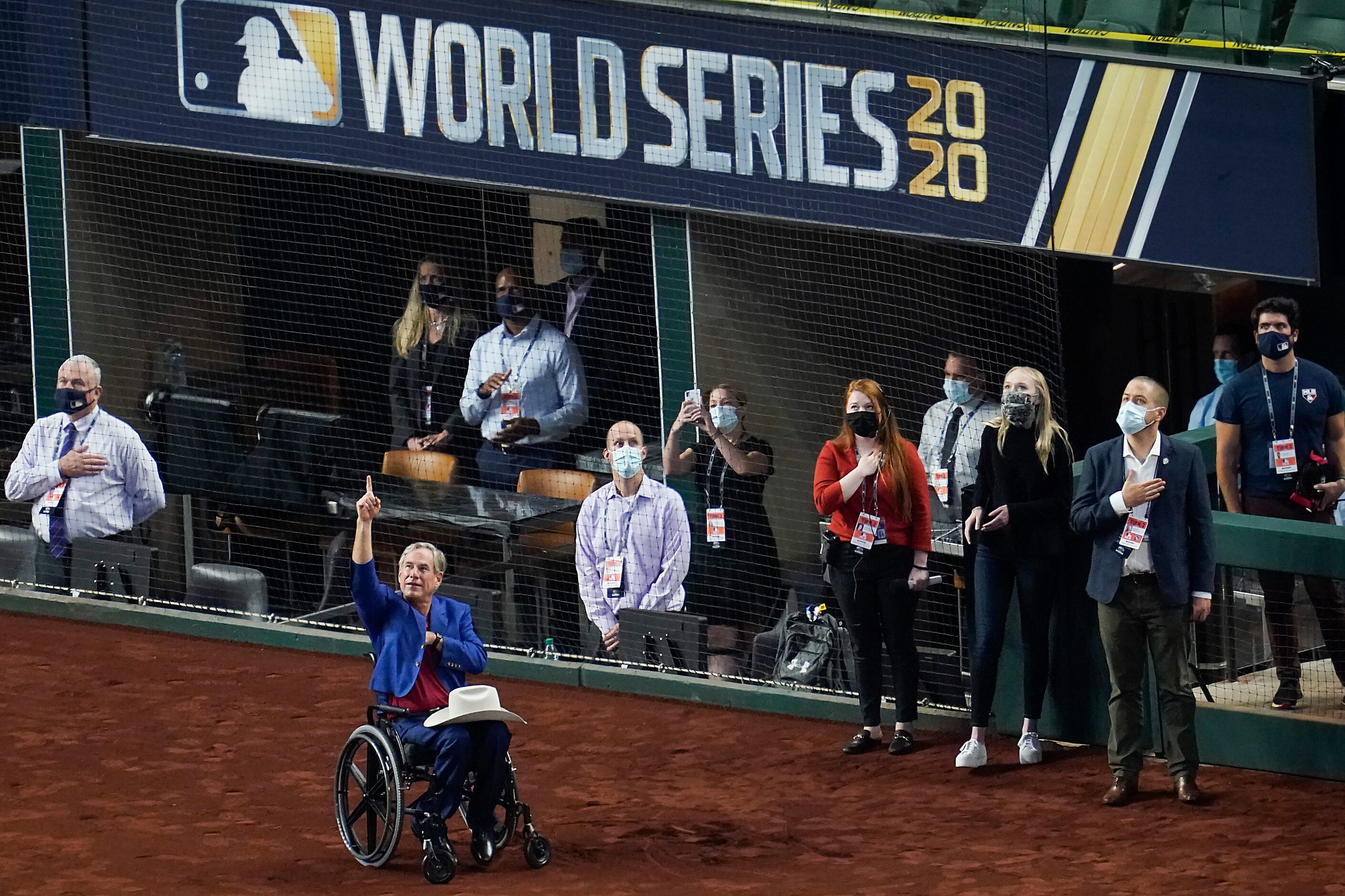 Texas Governor Greg Abbott points skyward for a flyover at the end of the national anthem...