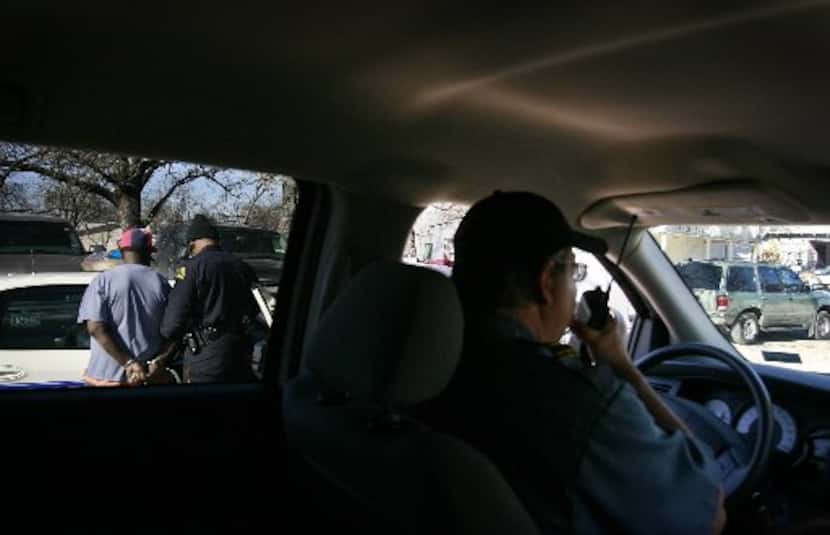 Lt. Robert Bailey (right), from city of Dallas parking enforcement, talked on a radio while...