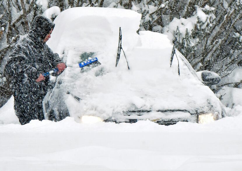  A man sweeps snow off of his car during the storm Saturday, Jan. 23, 2016 in Chambersburg,...
