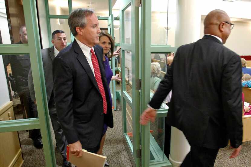  Texas Attorney Gen. Ken Paxton, left, arrives in court for a hearing on Paxton's felony...