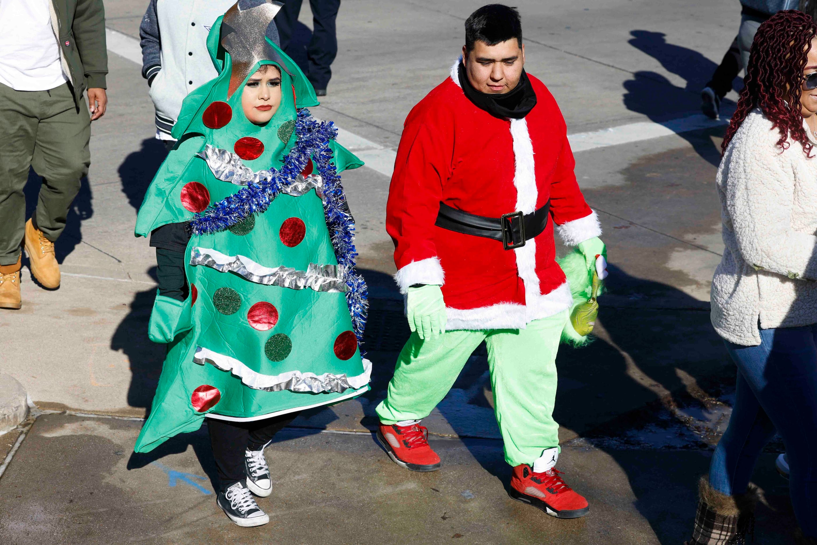 Fans wearing Christmas outfits make their way towards AT&T Stadium ahead of a NFL game...