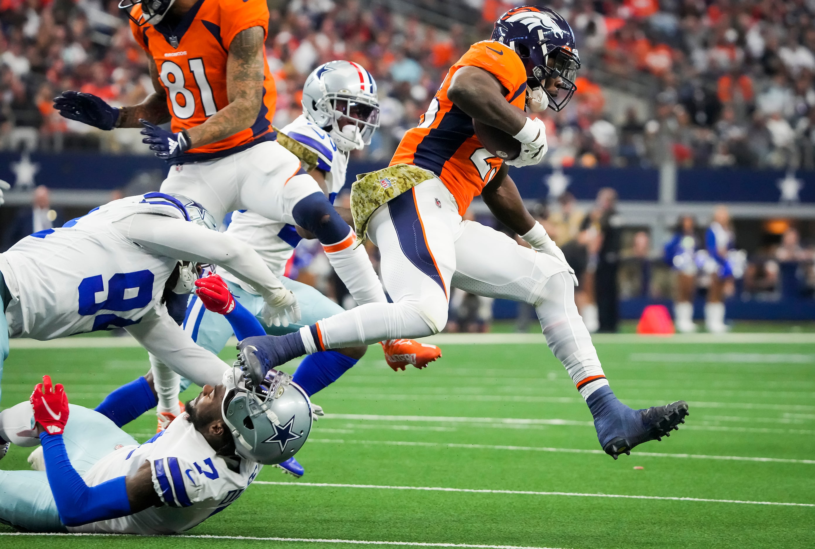 Denver Broncos running back Melvin Gordon (25) gets past Dallas Cowboys defensive back...