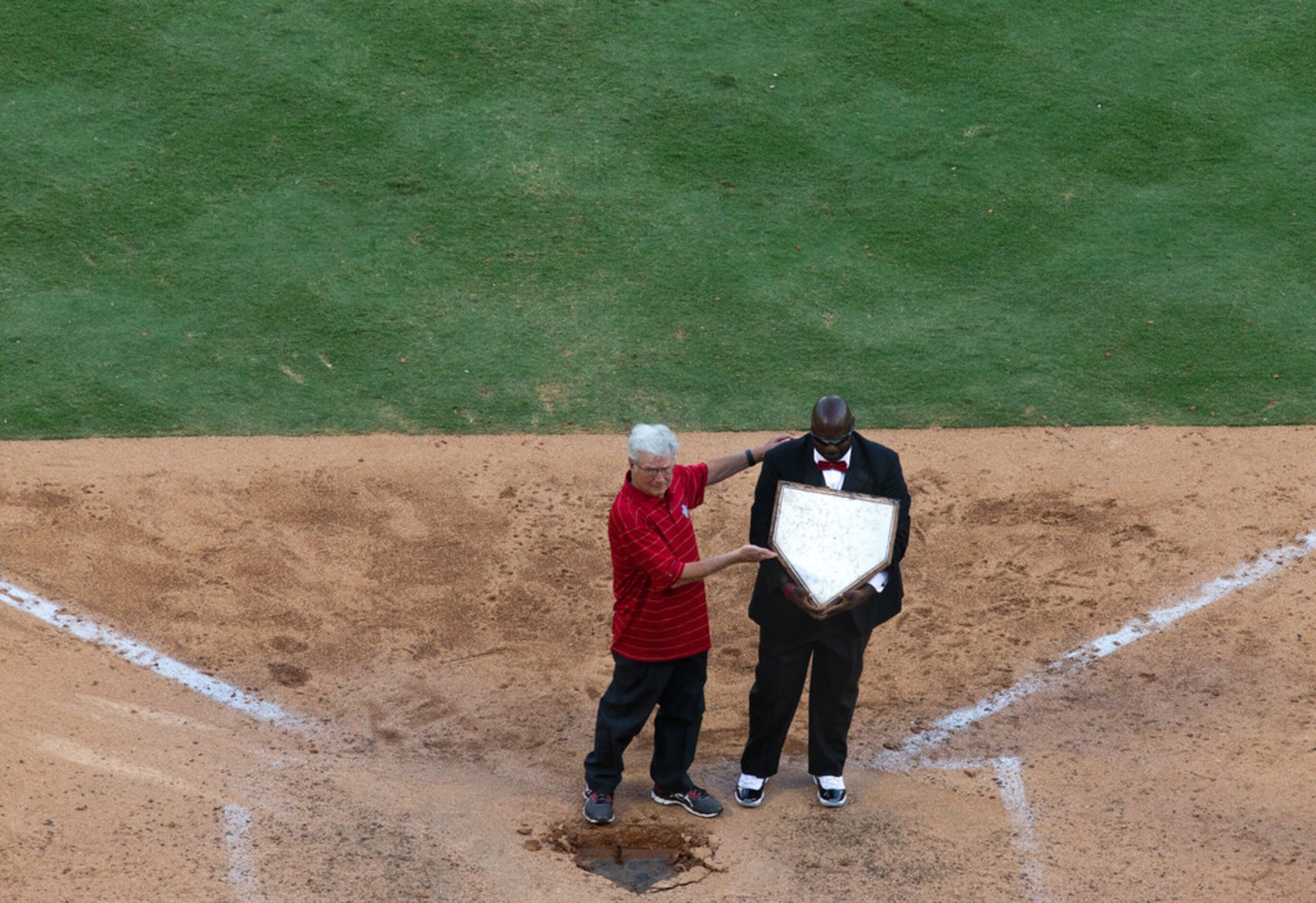 Former Arlington Mayor Richard Greene (left) and groundskeeper Devo Spencer lift up home...