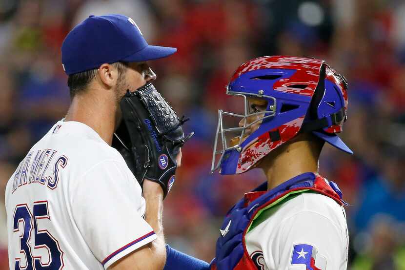 Texas Rangers starting pitcher Cole Hamels (35) talks with catcher Robinson Chirinos on the...