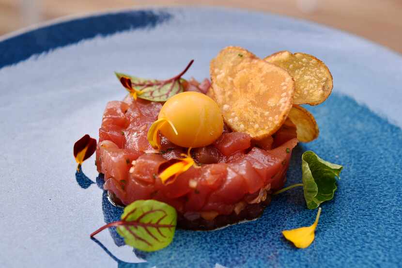 Tuna tartare, which is an appetizer, is served with radish, soy-lime vinaigrette and sea...