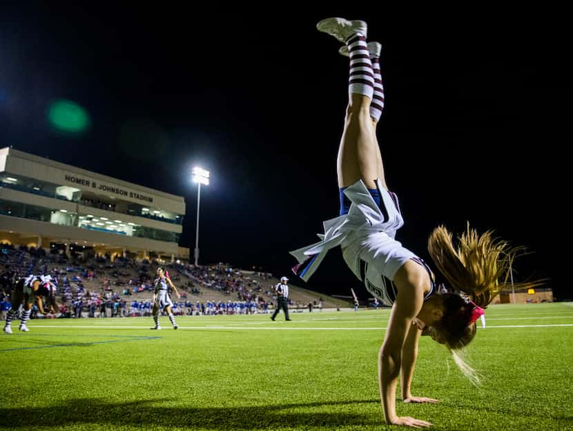Rowlett cheerleader Bailey Mathews flips in the end zone in celebration of a touchdown...