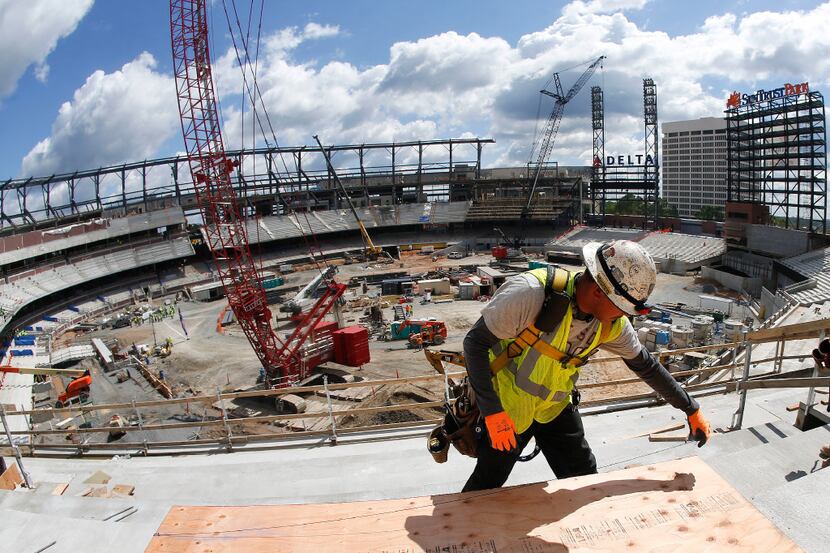 A worker measures a piece of wood as work continues on SunTrust Park, the future home of the...