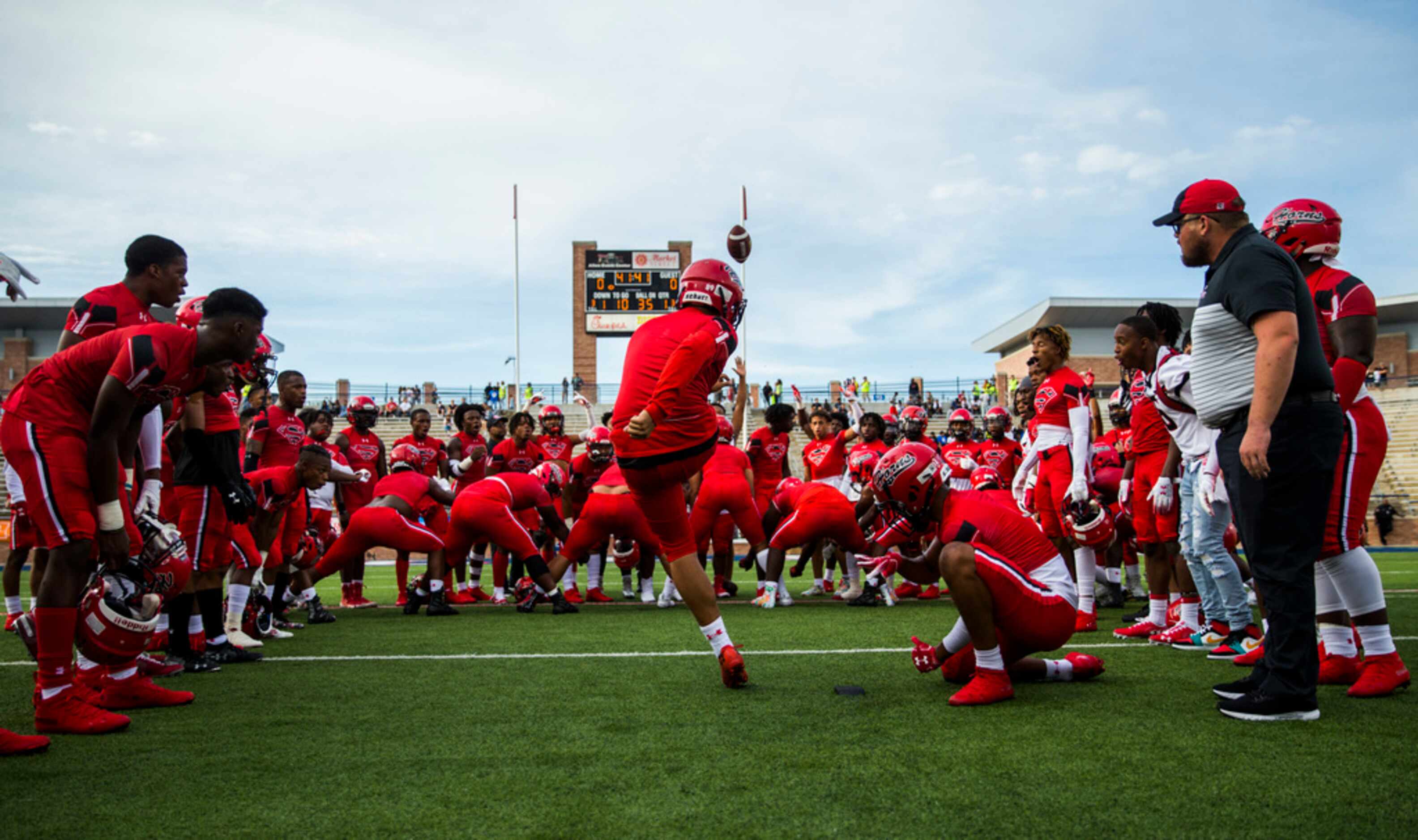 Cedar Hill players cheer on kicker Max Mata (89) as he warms up before a high school...