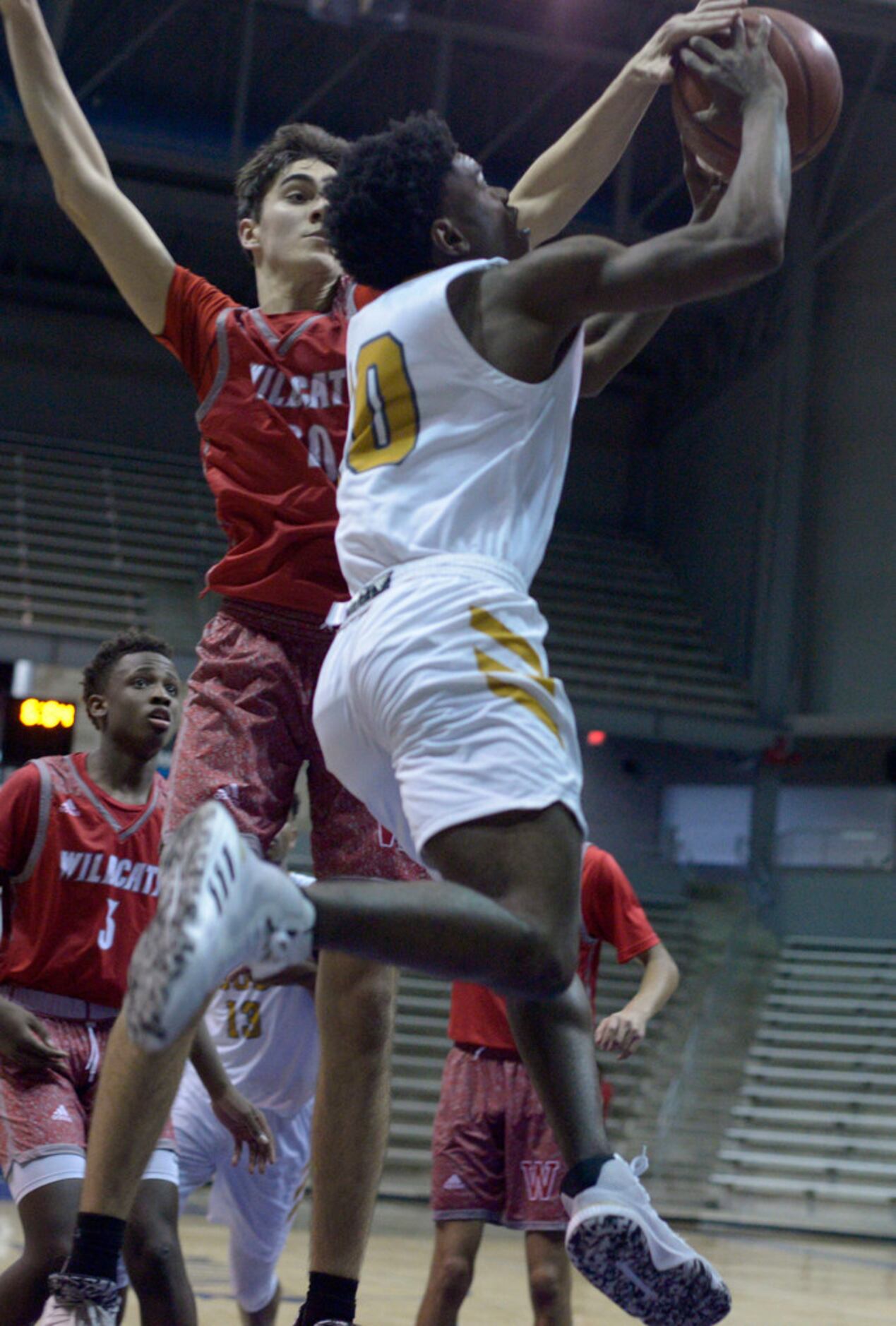Woodrow Wilson's Beau Becker (in red) blocks a shot by South Oak Cliff's Rickey Campbell in...