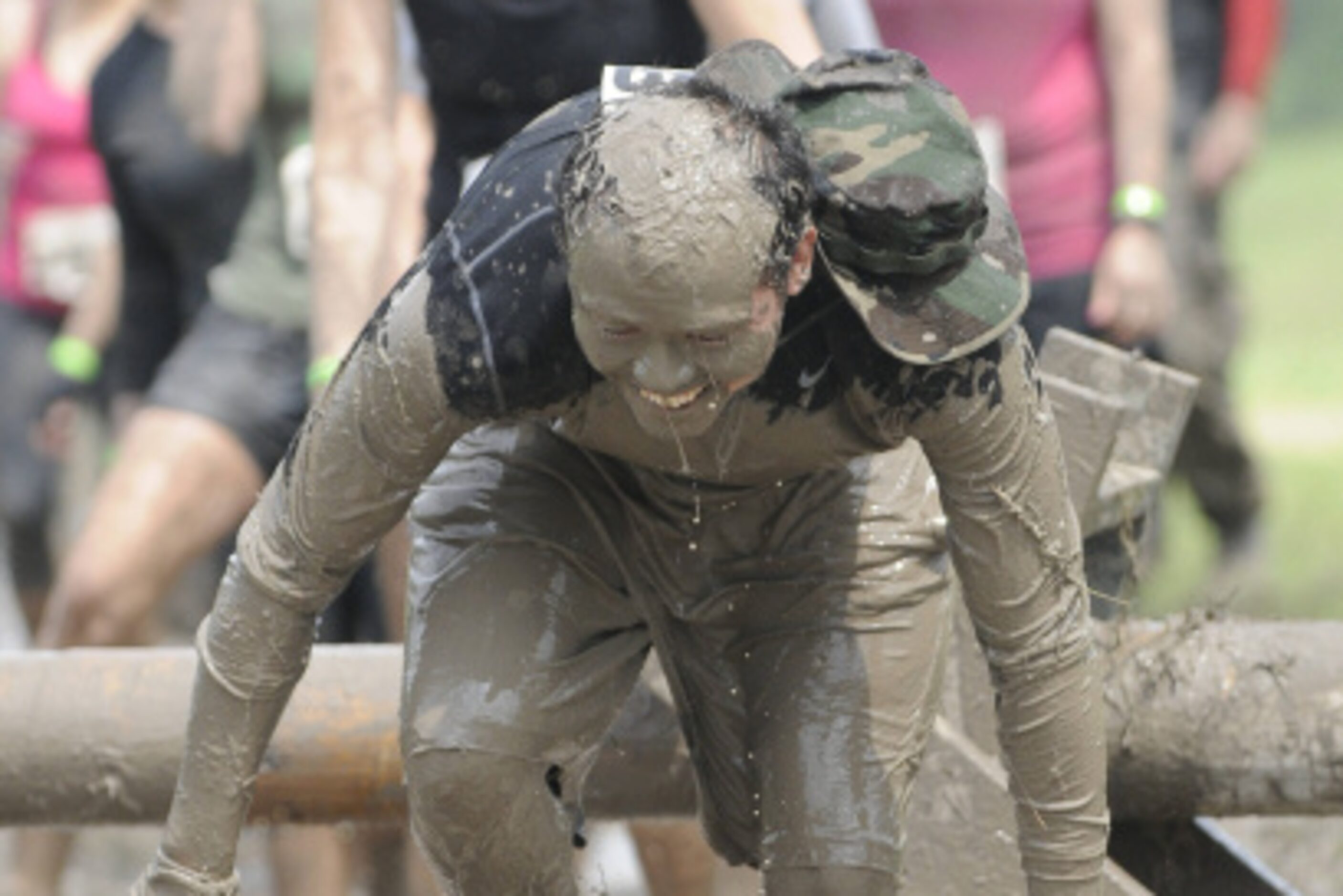 Eric Reynaga, a participant in the Original Mud Run, gets up after crawling under an obstacle.