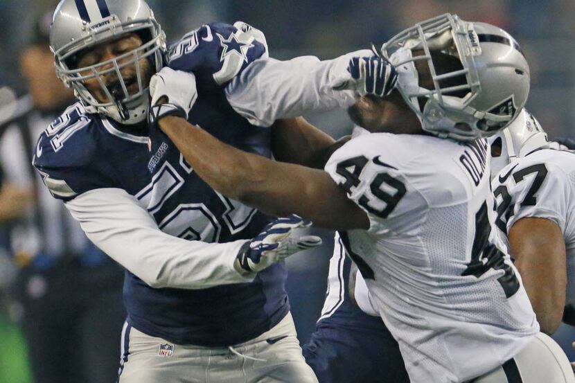 Dallas Cowboys defensive end Kyle Wilber (51) tangles with Oakland Raiders running back...