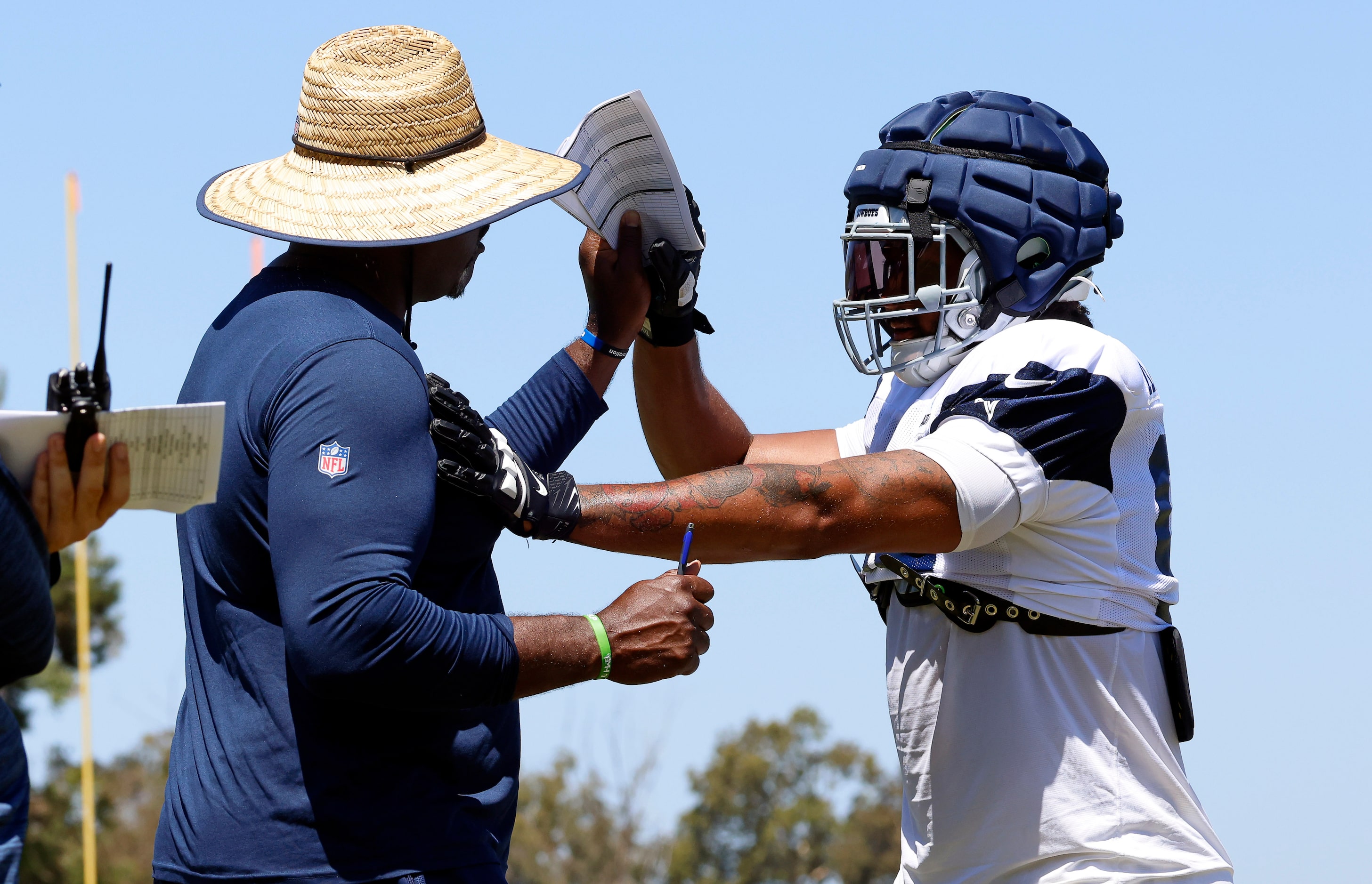 Dallas Cowboys defensive end Marshawn Kneeland (right) works with assistant defensive line...