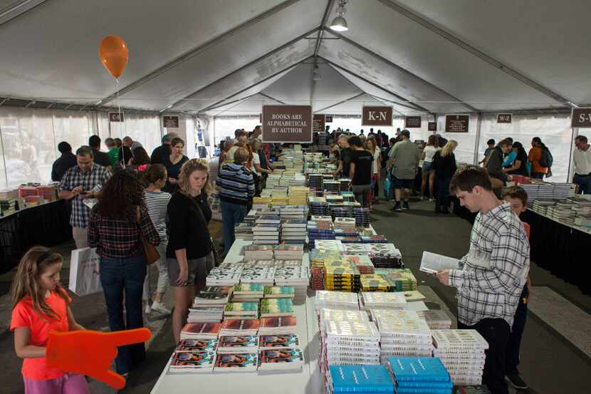 Festival goers look at books inside the Barnes and Noble tent during the Texas Book Festival...