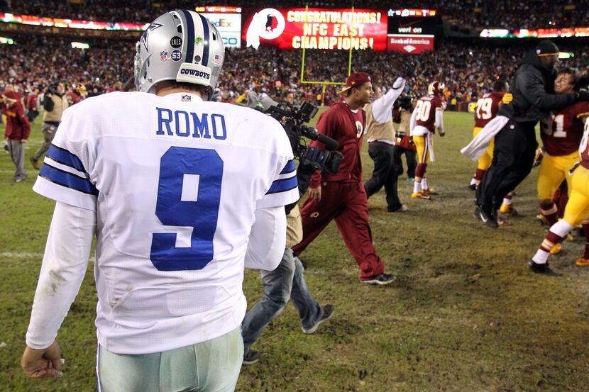 Tony Romo leaves the field as the Redskins celebrate winning the NFC East title. Washington...