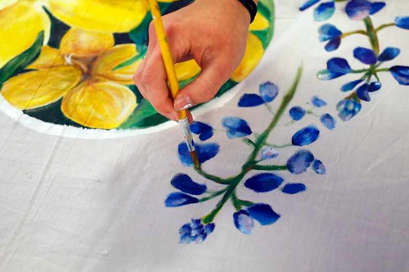 
Angie Reisch paints a bluebonnet on a mural meant to show solidarity between Charleston,...