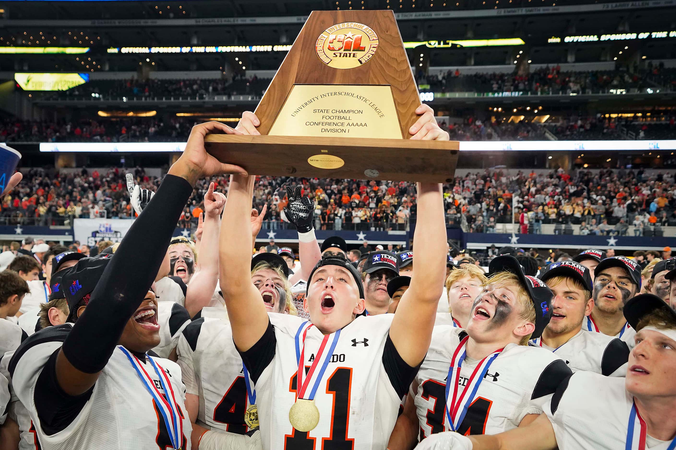 Aledo wide receiver Trace Clarkson (11) lifts the championship trophy after a victory over...
