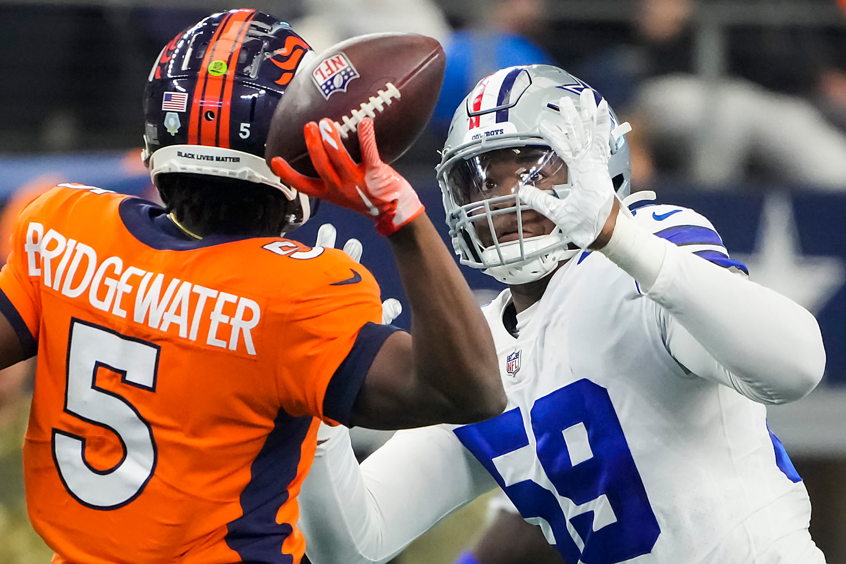 Denver Broncos quarterback Teddy Bridgewater (5) throws a pas under pressure from Dallas...