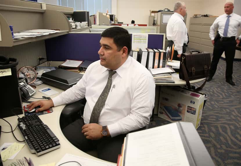Detective Noe Camacho, a member of the cold case unit, works at his desk at Dallas Police...
