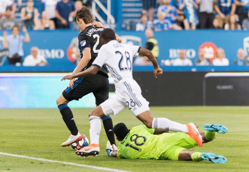 Montreal Impact's Lassi Lappalainen, left, scores against Philadelphia Union's goalkeeper...