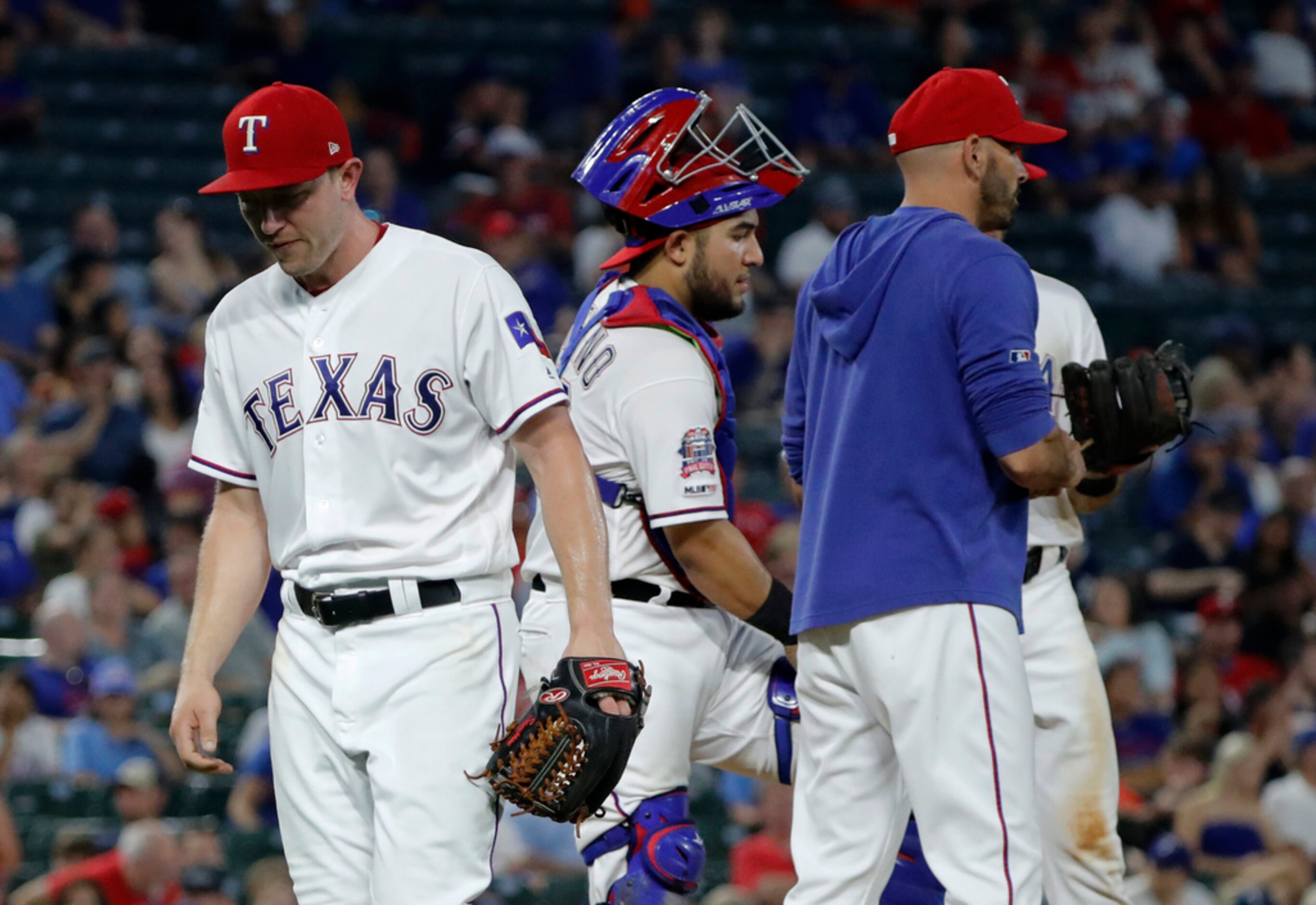 Texas Rangers starting pitcher Adrian Sampson, left, walks off the mound after turning the...