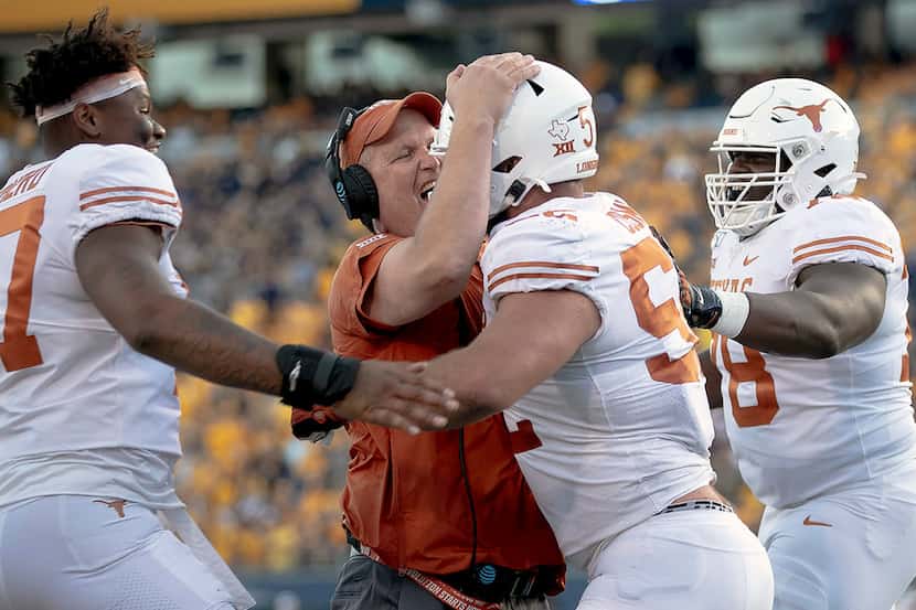 Texas lineman Samuel Cosmi (52) celebrates a touchdown with offensive line coach Herb Hand,...